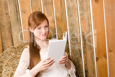 Young romantic woman in barn hold book