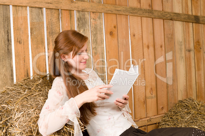 Young romantic woman in barn hold book