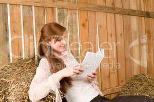 Young romantic woman in barn hold book