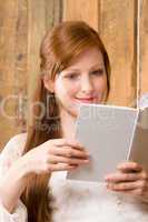 Young romantic woman in barn reading book