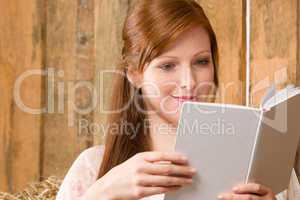 Young romantic woman in barn reading book
