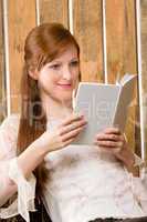 Young romantic woman in barn reading book