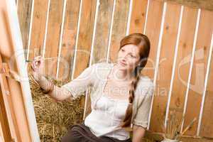 Red-hair romantic woman painting in barn