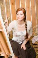 Red-hair romantic woman painting in barn