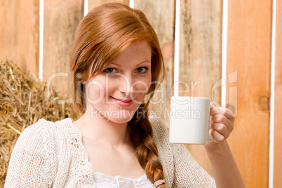 Young romantic woman in barn holding cup