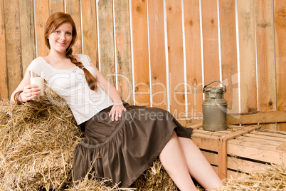 Young healthy woman hold glass of milk in barn
