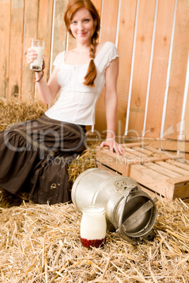 Young healthy woman hold glass of milk in barn