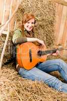 Young country woman  with guitar in barn