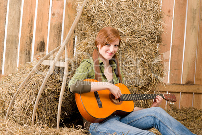 Young country woman  play guitar in barn