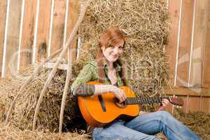Young country woman  play guitar in barn