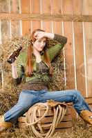 Provocative young cowgirl drink beer in barn