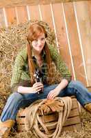 Provocative young cowgirl drink beer in barn