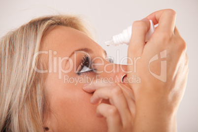 woman`s eye and eyedropper with waterdrop on tip