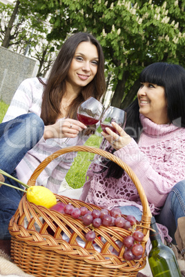 Mother and daughter drinking wine outdoors