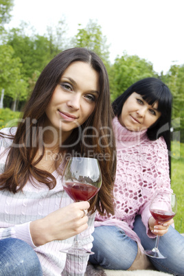 Mother and daughter drinking wine outdoors