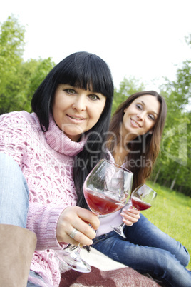 Mother and daughter drinking wine outdoors