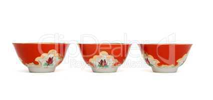 Three small asian porcelain drinking bowls with floral pattern isolated