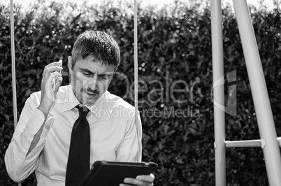 Business Man Working Outside with his Laptop and Cellphone