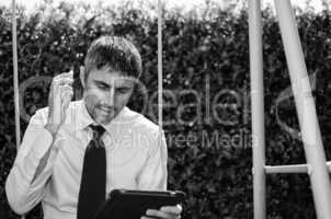 Business Man Working Outside with his Laptop and Cellphone