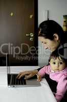 Mother using Laptop with her Daughter