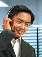 Male Sales Representative In His Office Talking On A Headset