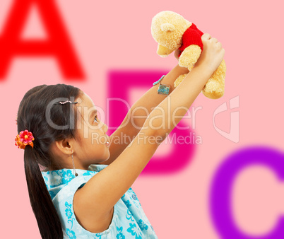 Girl Holding Her Teddy Bear Up In The Air