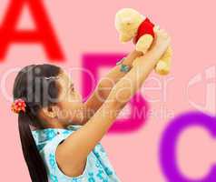 Girl Holding Her Teddy Bear Up In The Air