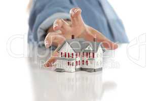 Womans Hand Reaching for Model House on White