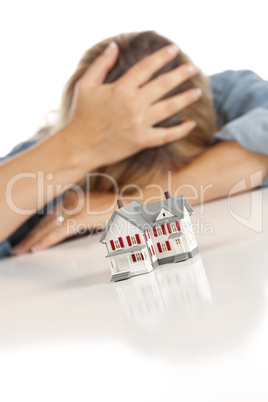 Woman with Head in Hand Behind Model Home