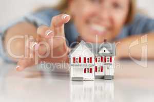 Smiling Woman Reaching for Model House on White