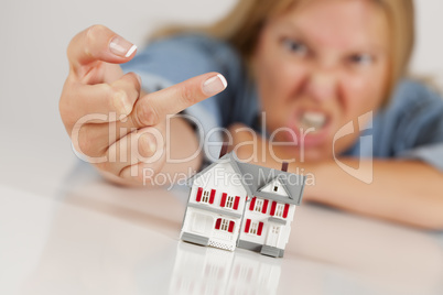 Angry Woman Flipping The Bird Behind Model Home on White