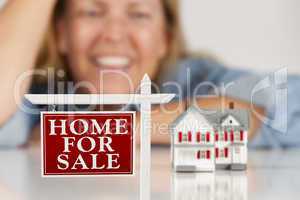 Smiling Woman Behind Real Estate Sign House on a White Surface