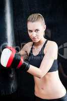 Boxing training woman in black hold punching bag