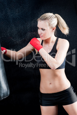 Boxing training blond woman sparring punching bag