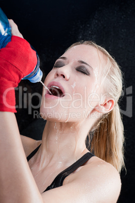 Boxing training woman pour water in her mouth
