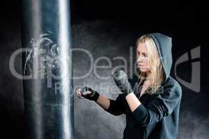 Blond boxing woman in black punching bag