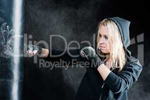 Blond boxing woman in black punching bag