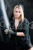 Boxing training woman in black hold punching bag