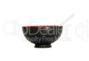 Black Oriental bowl with white spoon side view isolated