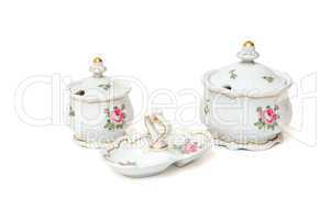 Two white porcelain sugar basins and double jam dish with roses isolated on white