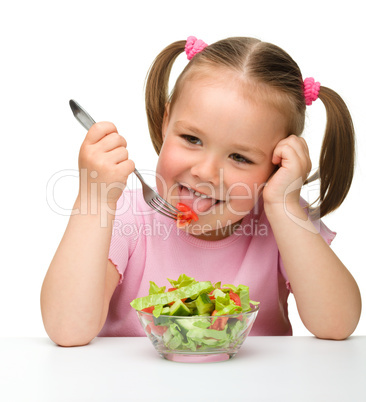 Cute little girl eats vegetable salad