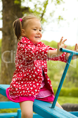 Cute little girl is swinging on see-saw