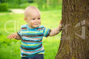 Little boy is playing hide and seek outdoors