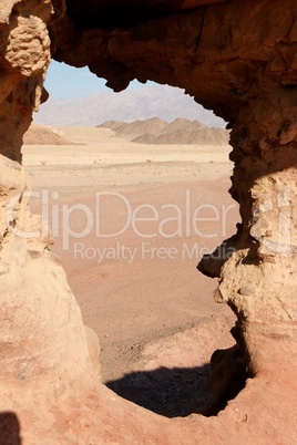 Window in the orange sandstone rock in desert