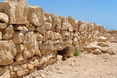 Broken wall of ancient fortress ruin converging in perspective
