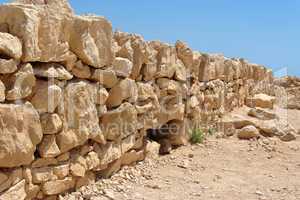 Broken wall of ancient fortress ruin converging in perspective