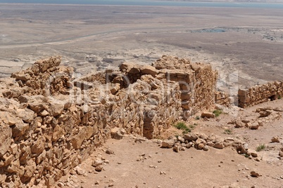 Ruined wall of ancient fortress on the mountain in the desert