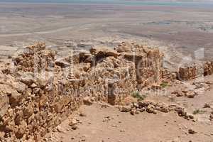 Ruined wall of ancient fortress on the mountain in the desert