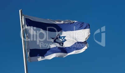Israel flag waving in the wind against a blue sky