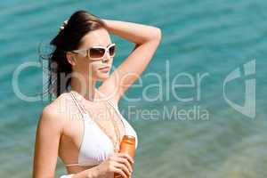 Summer young woman with suncream in bikini